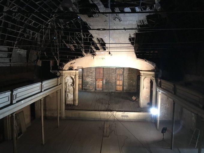 back balcony shot of entire opera house including the stage. Falling down ceiling and cables securing the structure