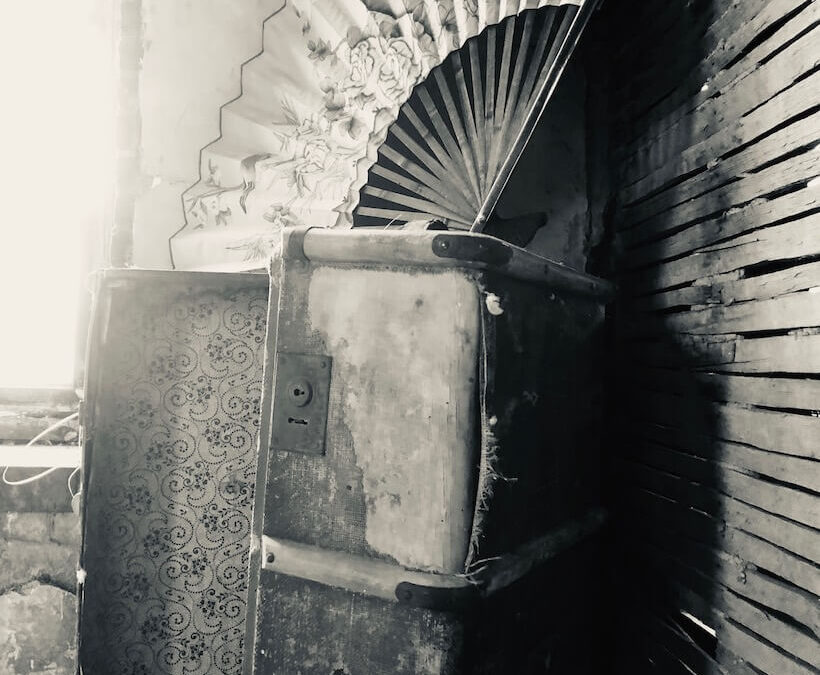 black and white picture of antique truck and over sized fan in room of opera house